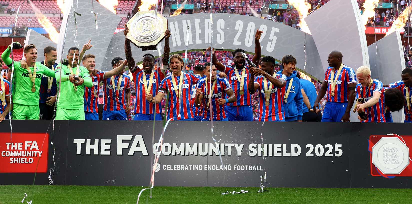 Mark Joyei from Crystal Palace raises the cup as he celebrates with his teammates after winning the English FA shower shield 