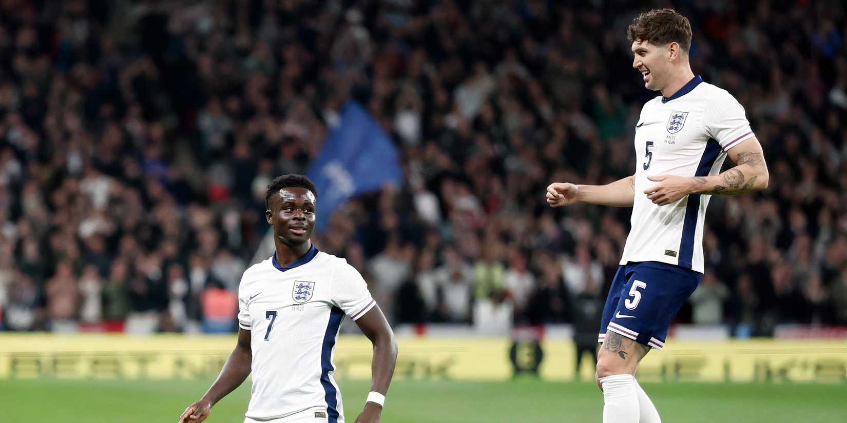 Bukayo Saka and John Stones celebrate with the England national team