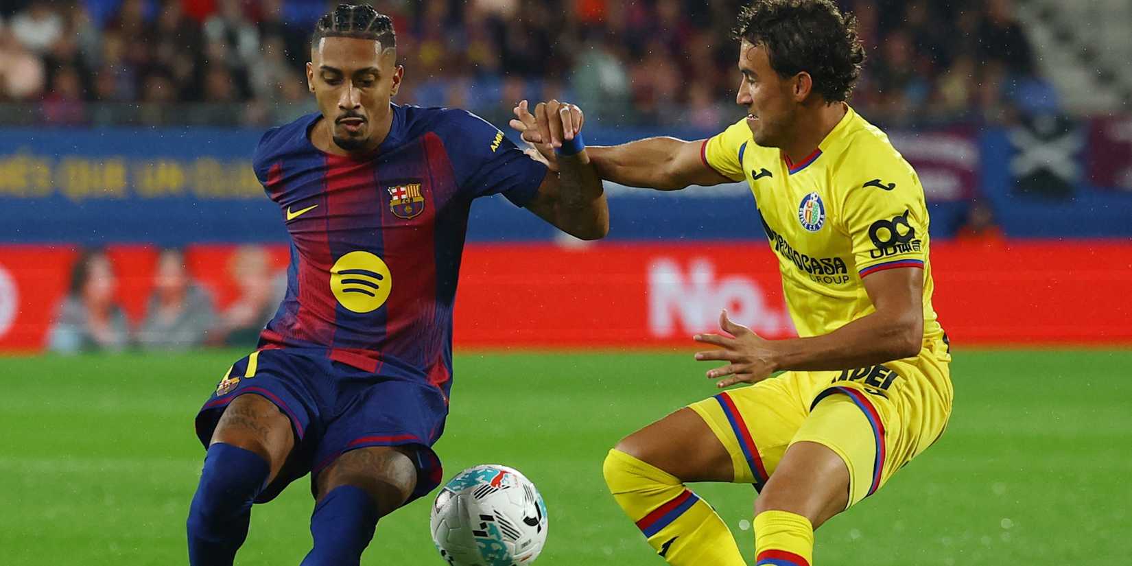 FC Barcelona's Raphinha in action with Getafe's Luis Milla