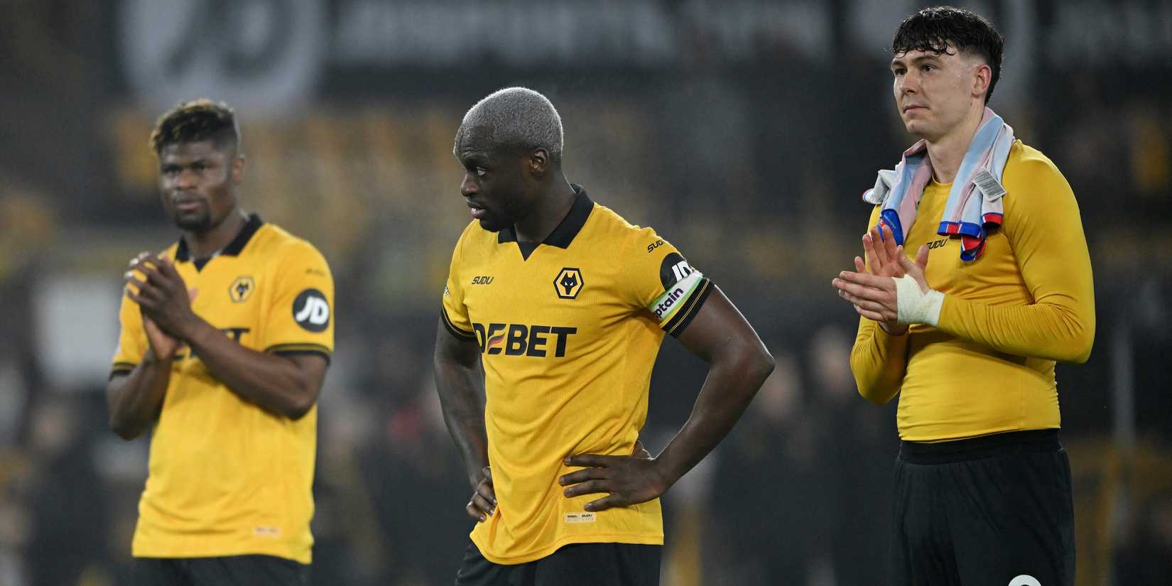 Wolverhampton Wanderers' Toti Gomes looks dejected as Jorgen Strand Larsen and Emmanuel Agbadou applaud fans after the match