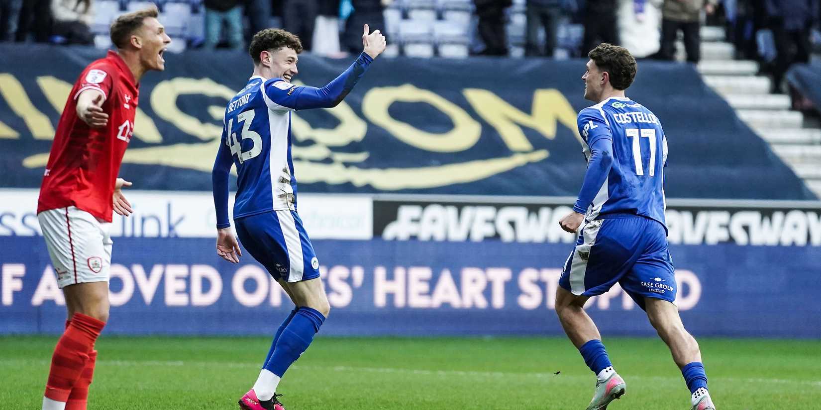 Dara Costello, do Wigan Athletic (à direita), comemora seu primeiro gol com seu companheiro de equipe Harrison Bettoni