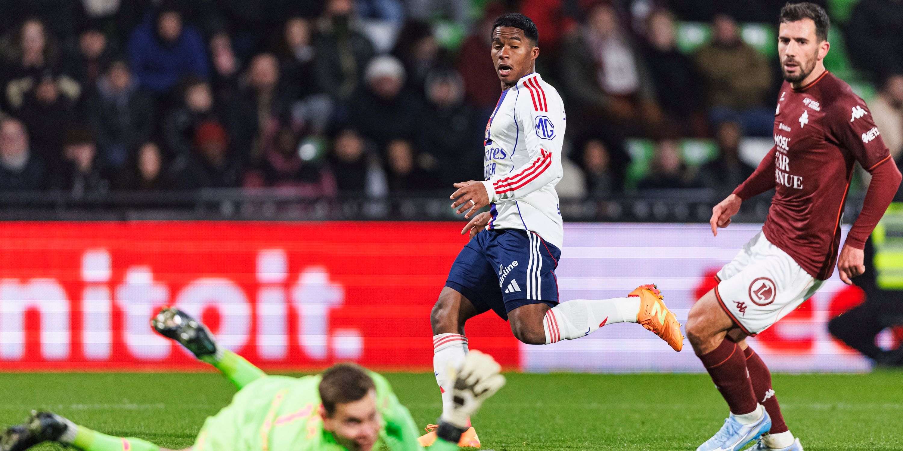 Endrick de Sousa of Lyon (L) attempts a kick while being defended by Goalkeeper Jonathan Fischer of FC Metz