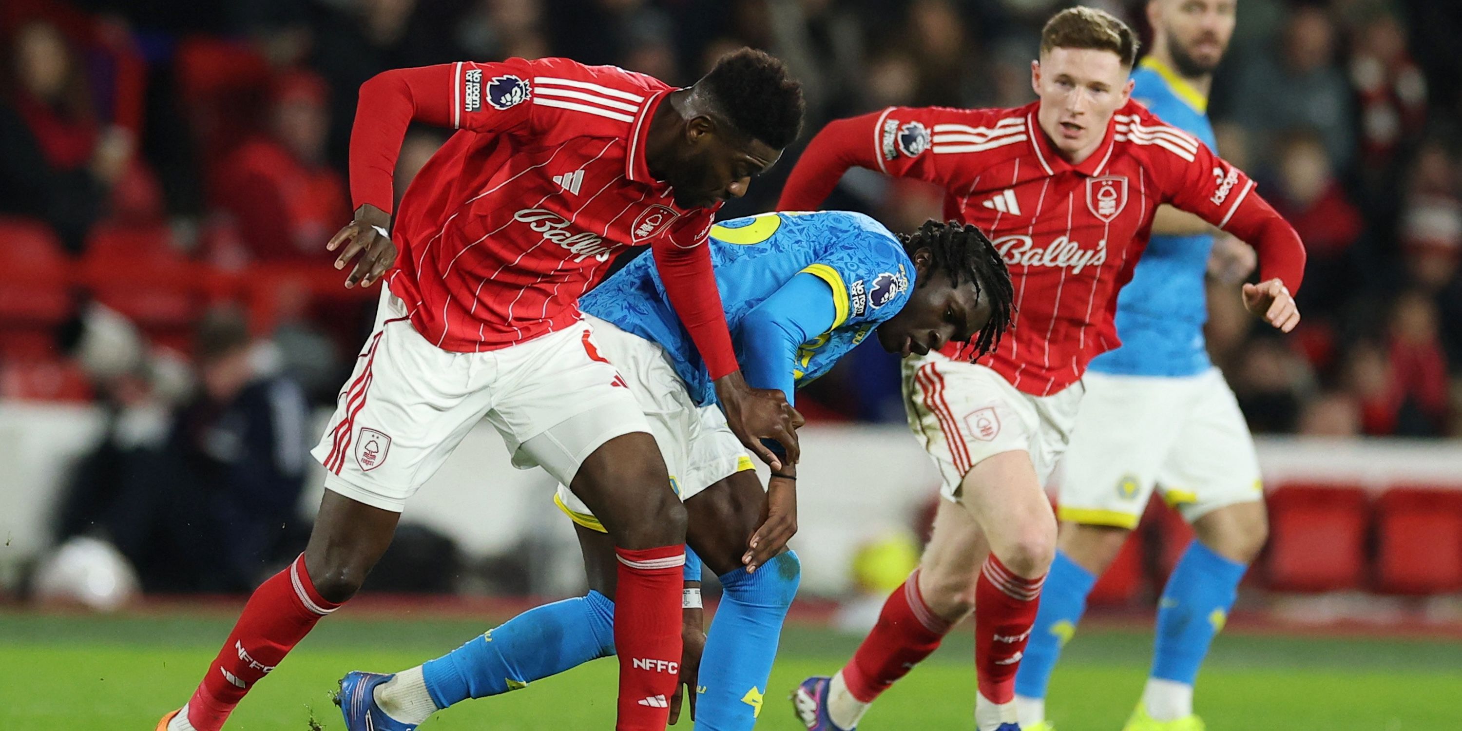 Ibrahim Sanghari e Elliott Anderson do Nottingham Forest em ação com Mattis Mane do Wolverhampton Wanderers