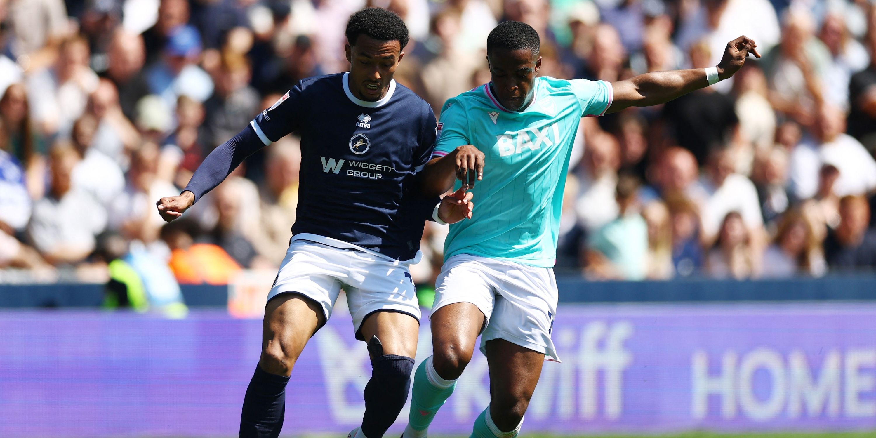 Femi Azeez, do Millwall, em ação com Aidomo Emakhu, do Oxford United 