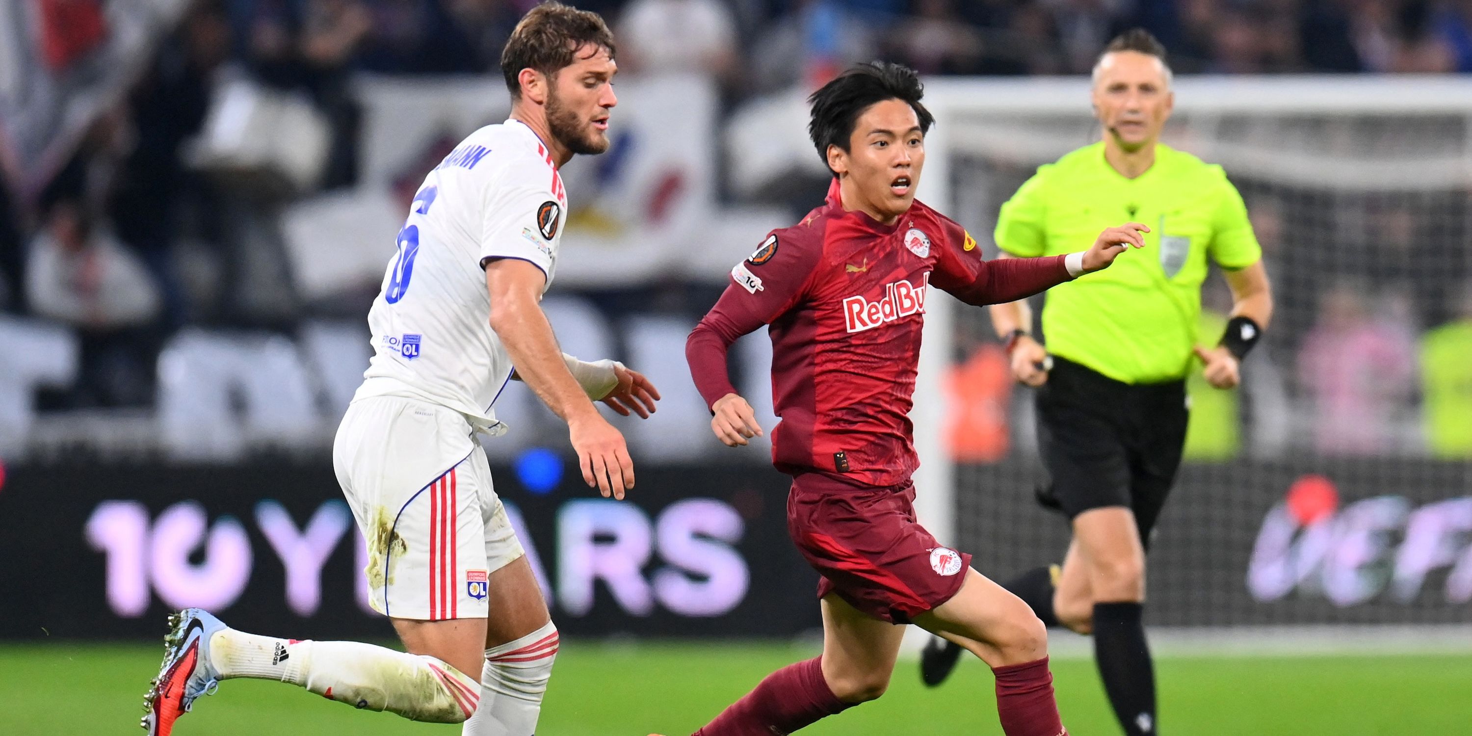 Olympique Lyonnais' Tanner Tessmann in action with RB Salzburg's Sota Kitano
