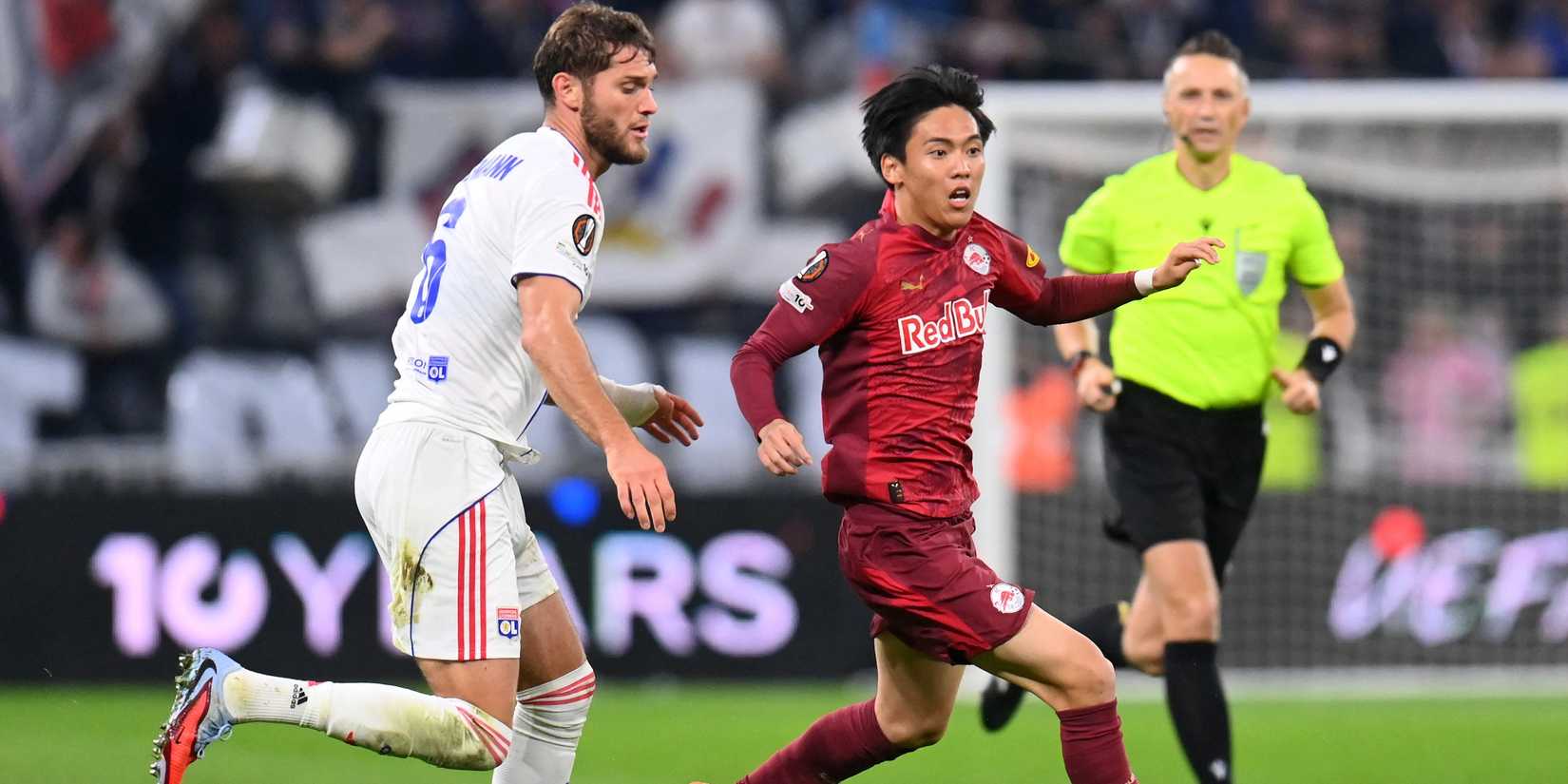 Olympique Lyonnais' Tanner Tessmann in action with RB Salzburg's Sota Kitano