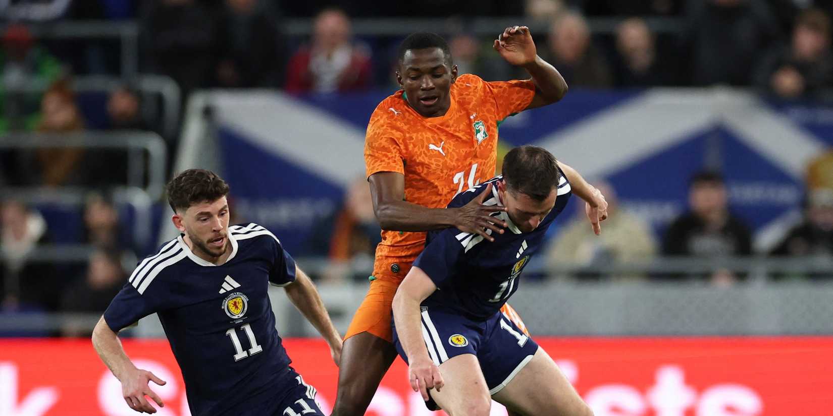 Ivory Coast's Bazoumana Toure plays with Scotland's Ryan Christie and Dominic Hyam