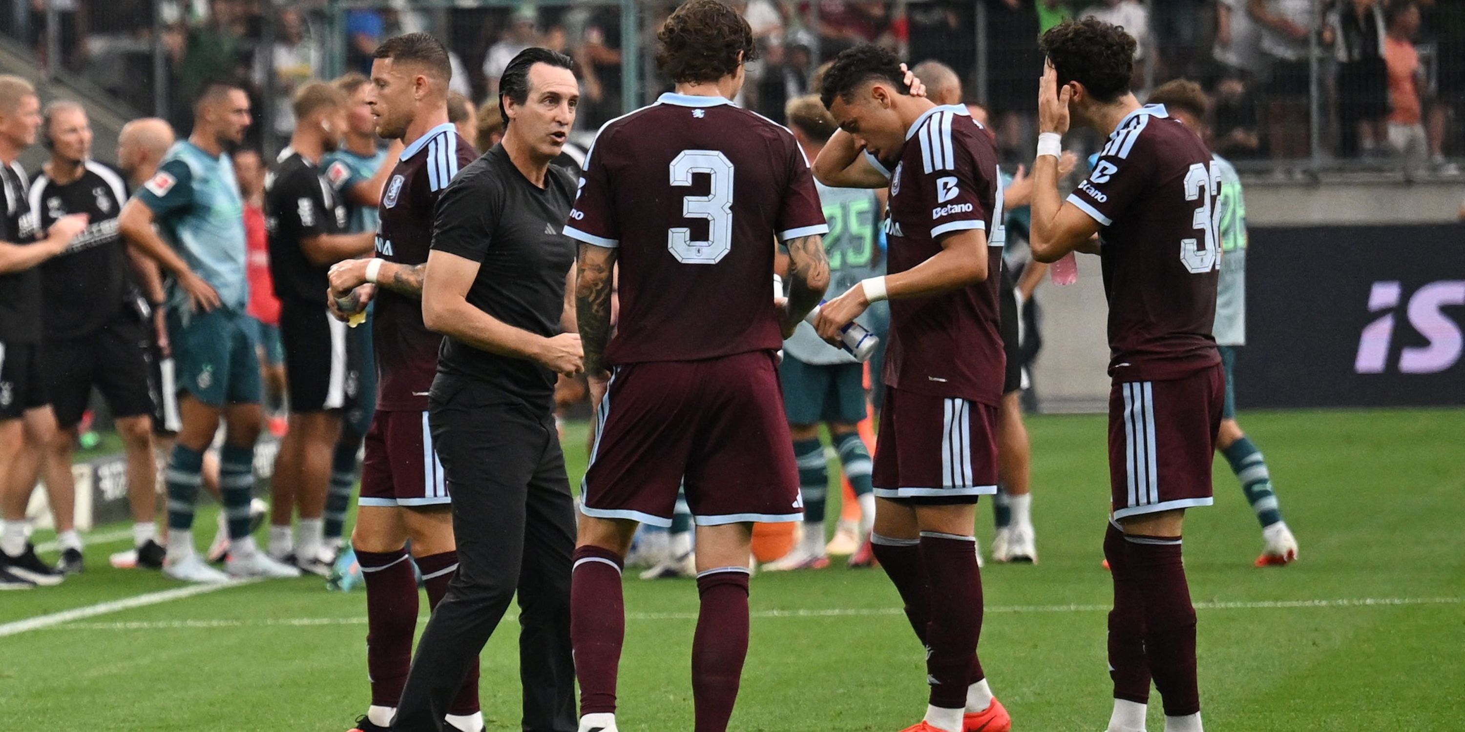 Aston Villa manager Unai Emery speaks with Victor Lindelof and teammates during a break in play 