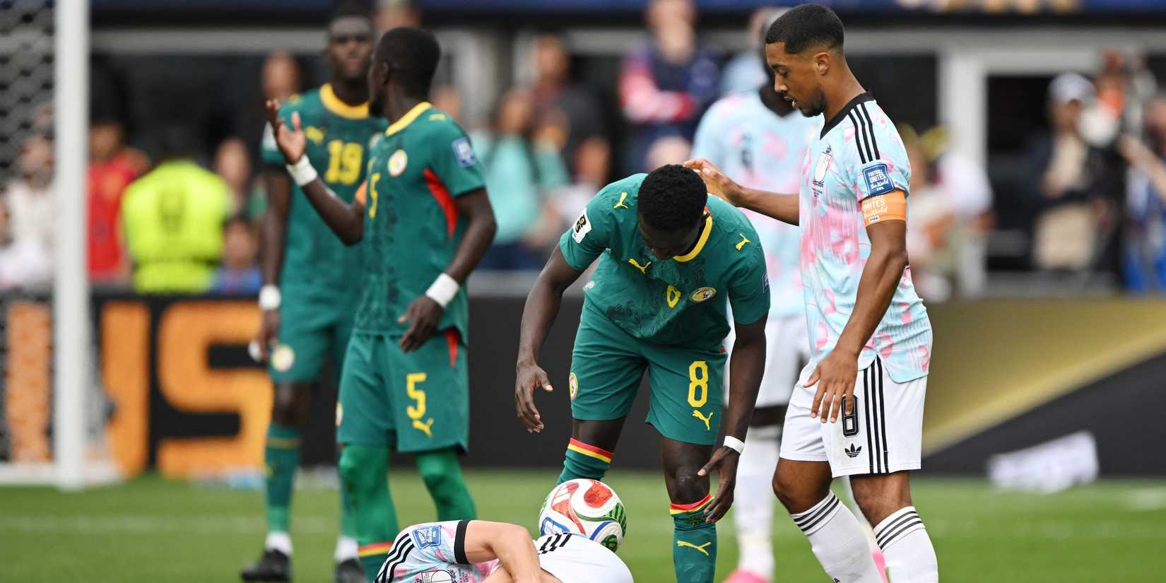 Belgium's Leandro Trossard reacts after sustaining an injury as Senegal's Lamine Camara and Belgium's Youri Tielemans look on