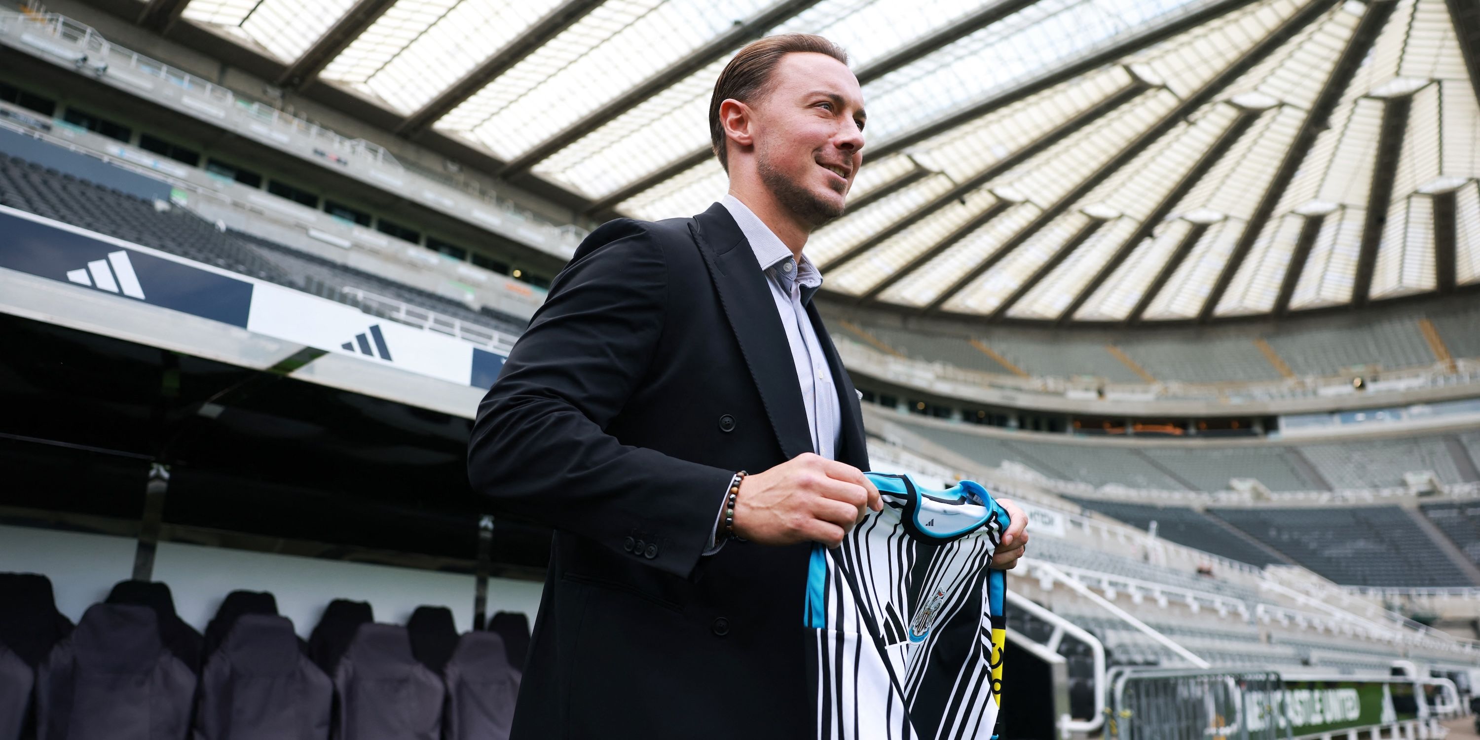 Newcastle United manager Matthias Jaissle poses with the home kit on the pitch